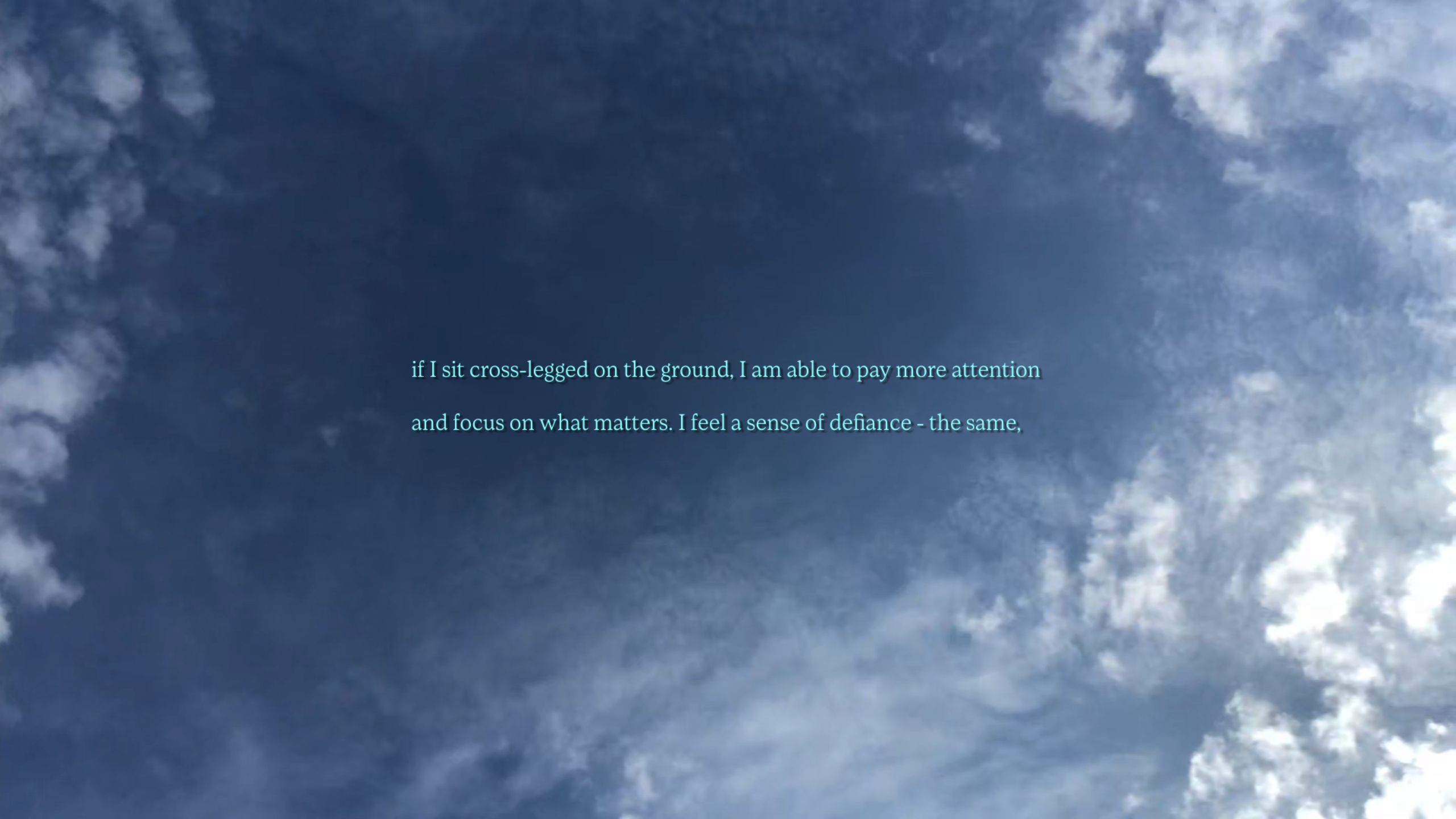 Image shows a screenshot of a blue sky with light clouds. Turquoise writing is imposed over the top, which reads, if I sit cross-legged on the ground, I am able to pay more attention and focus on what matters. I feel a sense of defiance - the same,